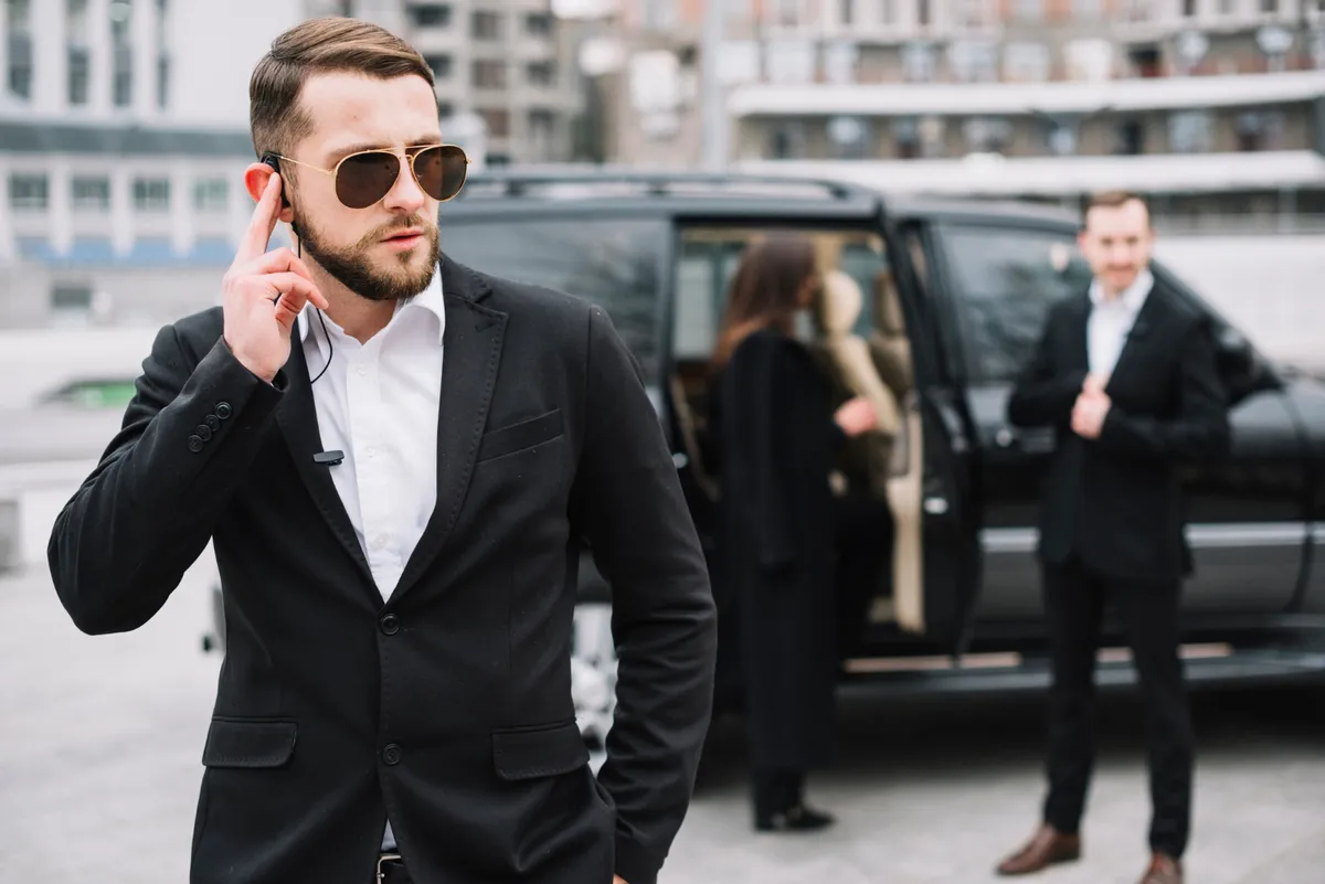 Suited security professional communicating through an earpiece