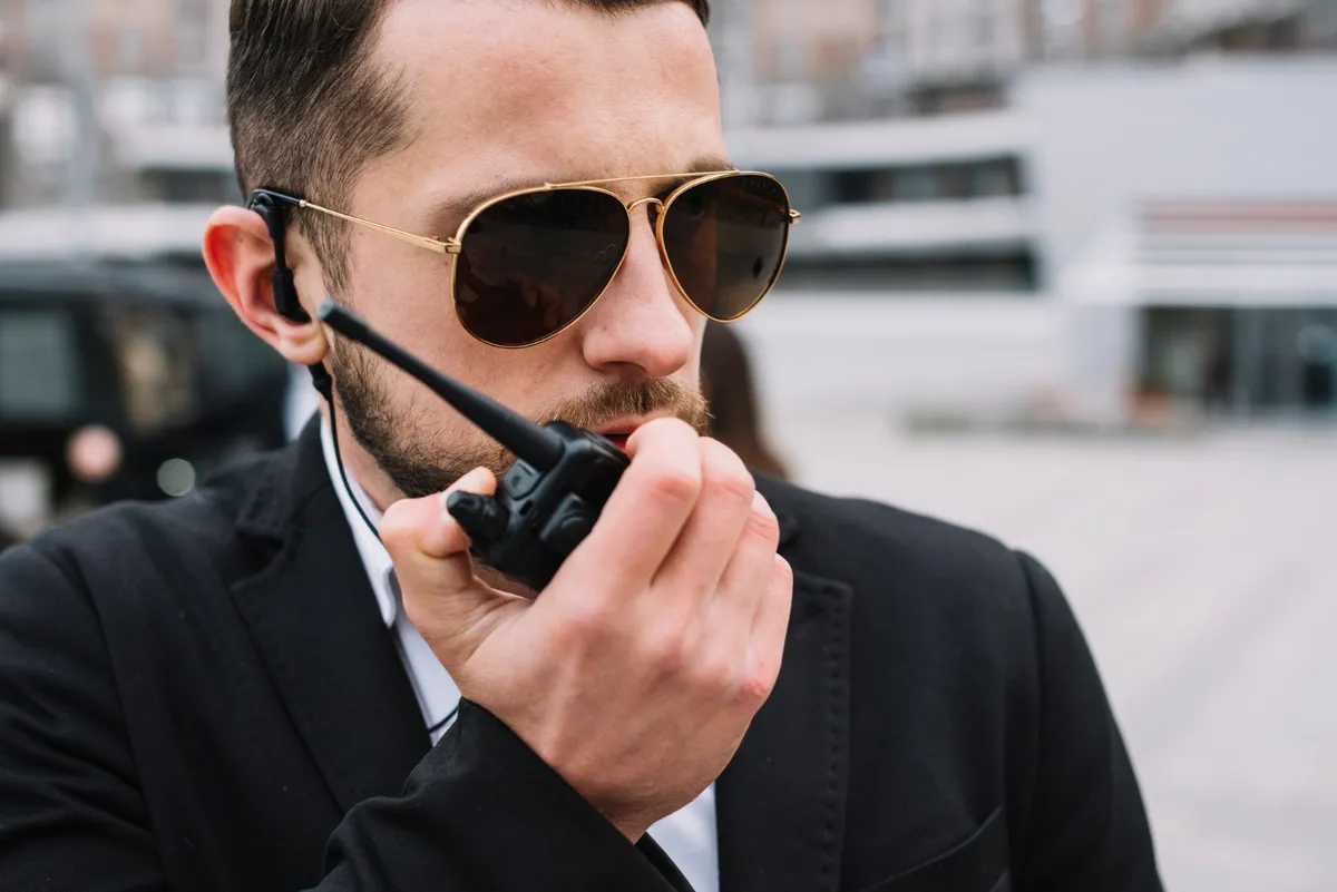 Security professional speaking into a handheld radio